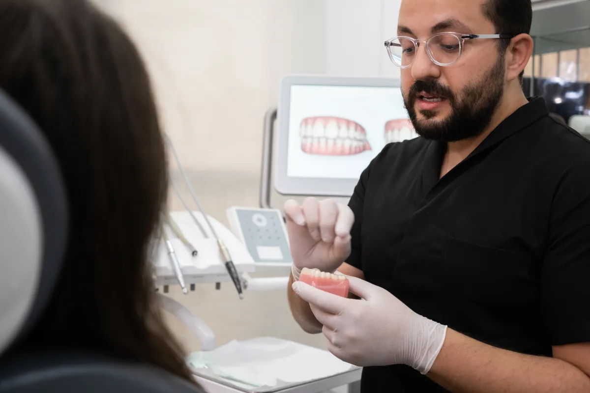 Dentista explicando para paciente os fatores que influenciam o investimento em tratamento ortodôntico durante consulta de avaliação